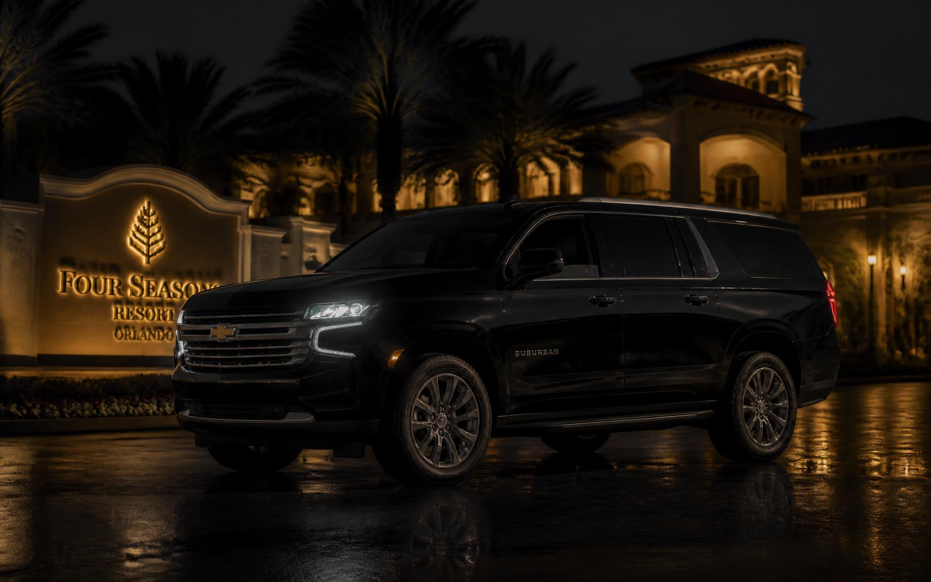 Black Chevrolet Suburban waiting outside a luxury Orlando resort at night